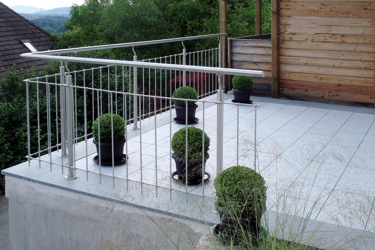 Balkong med rostfritt stålräcke, klinkergolv och krukväxter