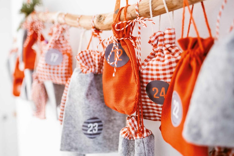 Adventskalender med tygpåsar, nummerskyltar och trästång