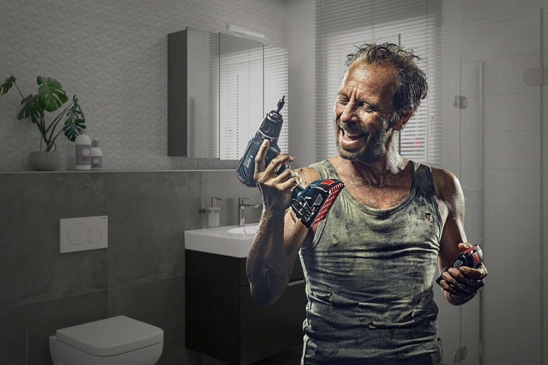 Man med sladdlös skruvdragare i ett badrum