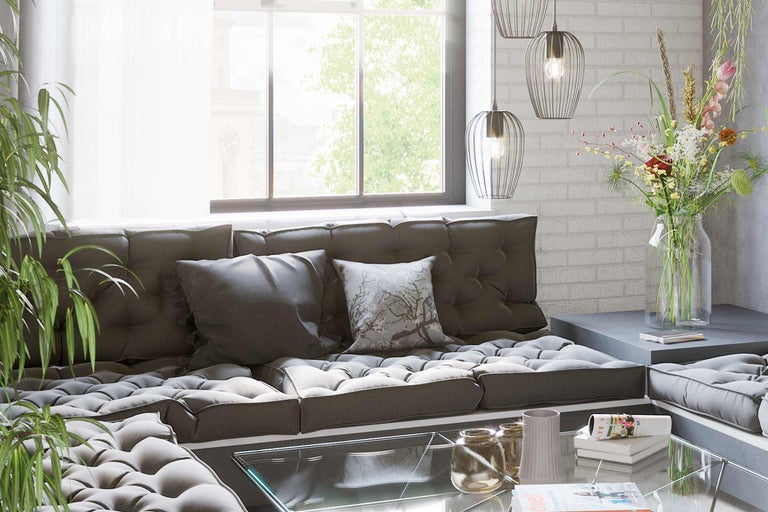 Vardagsrum med modulsoffa, soffbord i glas, blommor och hänglampor