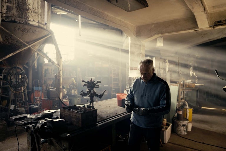 Verkstad med arbetsbänk, verktyg och en man som arbetar