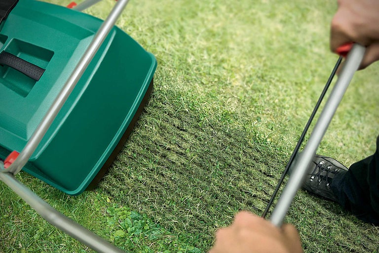 Trädgårdsredskap för gräsmatteskötsel som används på en gräsmatta.