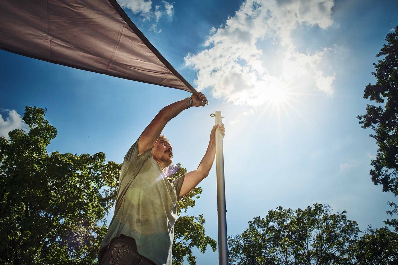 Kvinna fäster insynsskyddsduk med krokar på balkongen