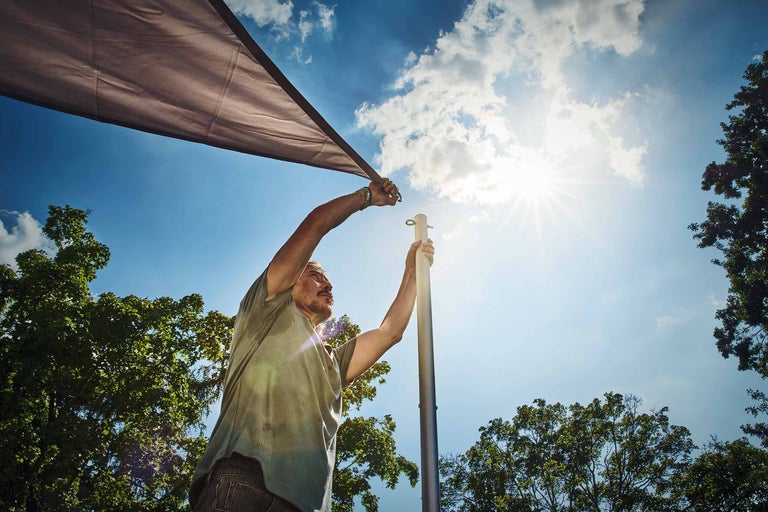 Kvinna fäster insynsskyddsduk med krokar på balkongen