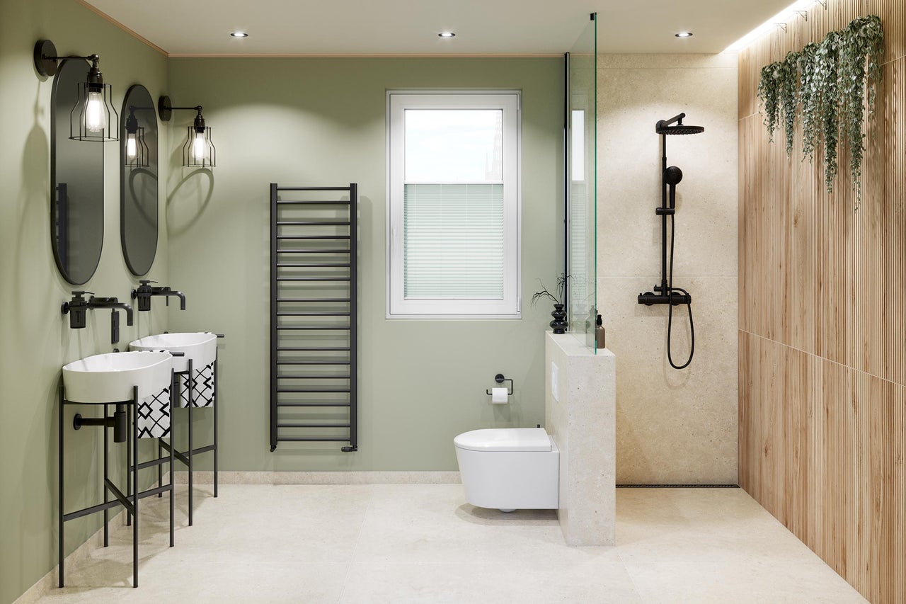 Modernt badrum med två tvättställ, ovala speglar, svart handdukstork, vägghängd toalett och dusch med väggpaneler i trälook.