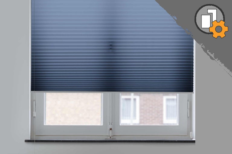 Blå plisségardin på fönstret för ljusreglering