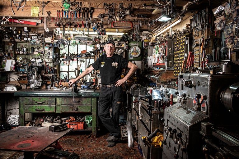 Verkstad med verktyg, arbetsbänk och en person