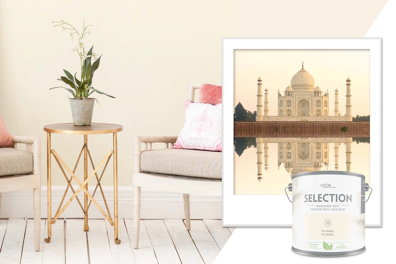 Vardagsrumsscen med färgburk, bord, stol och inramad bild av Taj Mahal