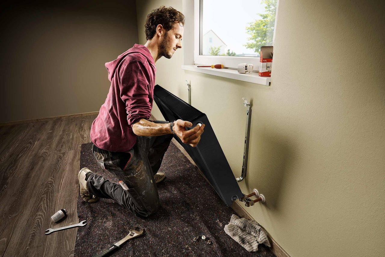 Man installerar ett element i ett rum. Verktyg finns till hands.