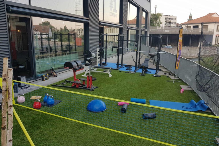 Utomhusområde för gym med träningsutrustning och tillbehör på konstgräs