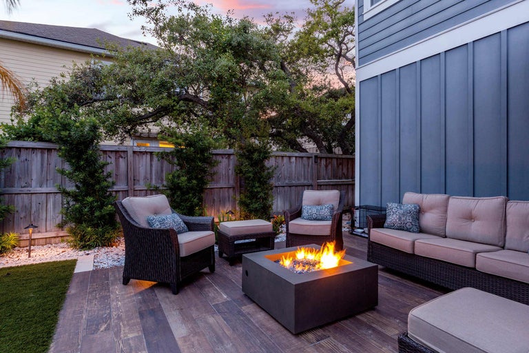 Uteplats med sittgrupp, eldstad och trädgård