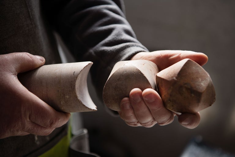 En person håller träskruvformar i handen.