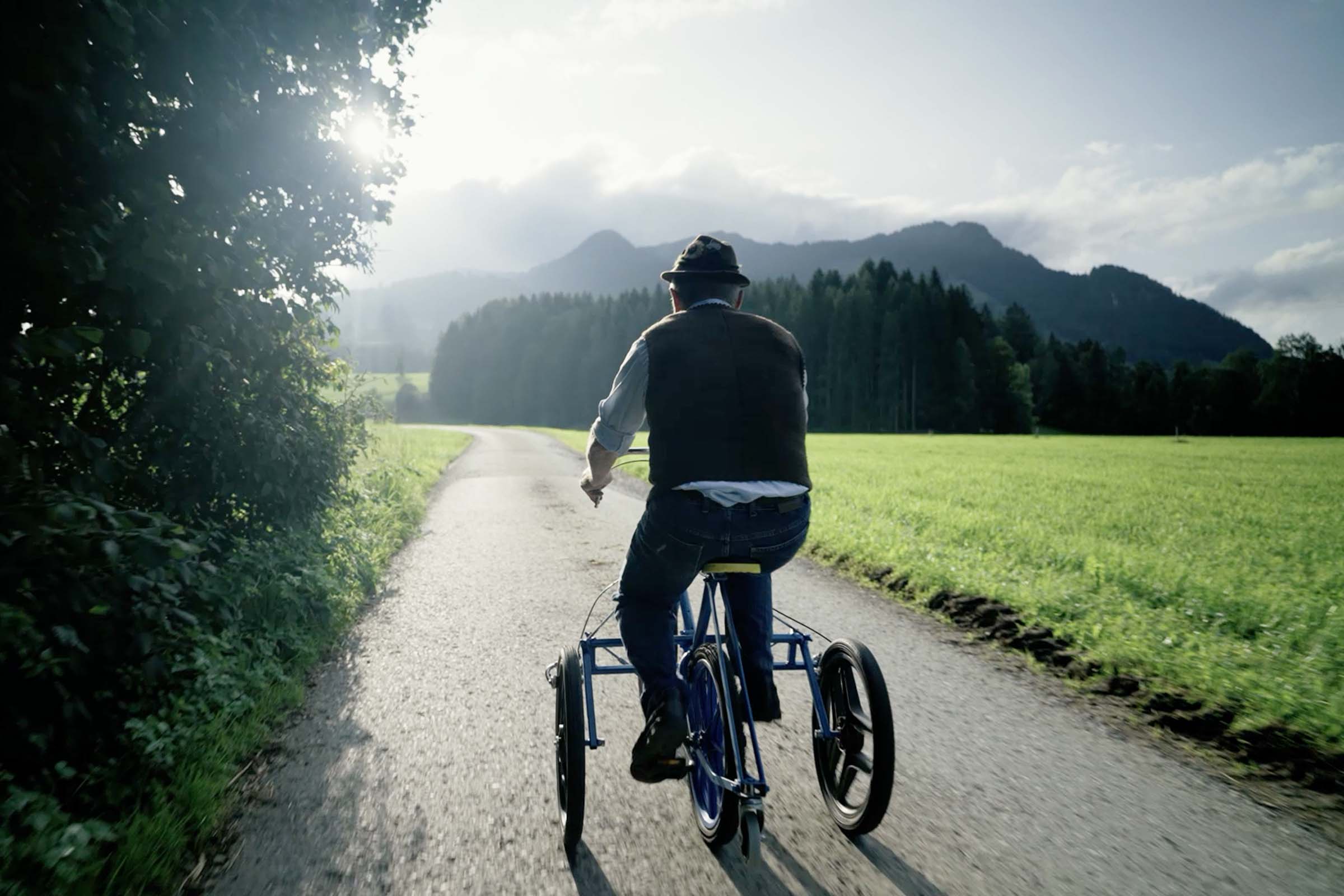Man cyklar trehjuling på en landsväg