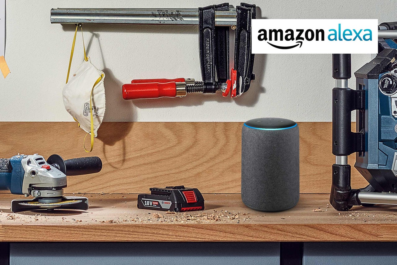 Verkstadsscen med Amazon Alexa, slipmaskin, batteri, skruvtvingar och andningsskydd