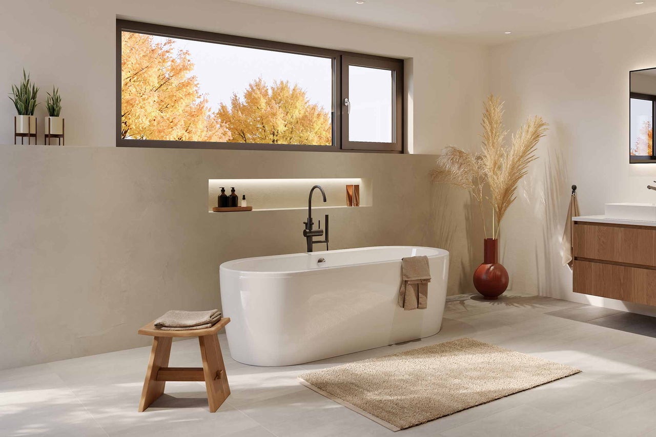 Ljust badrum med fristående badkar, träpall och fönster