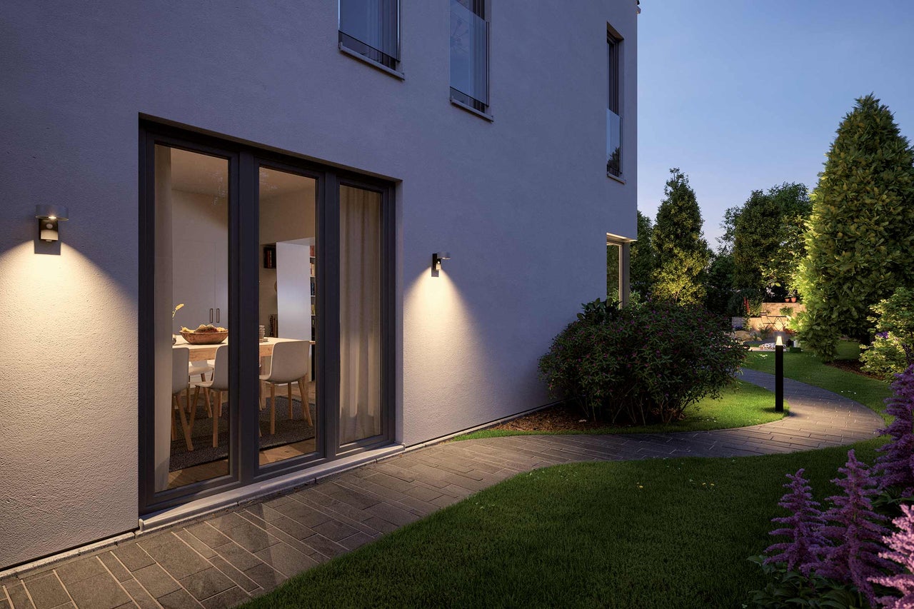 Belyst hus med trädgårdsgång och utomhusbelysning