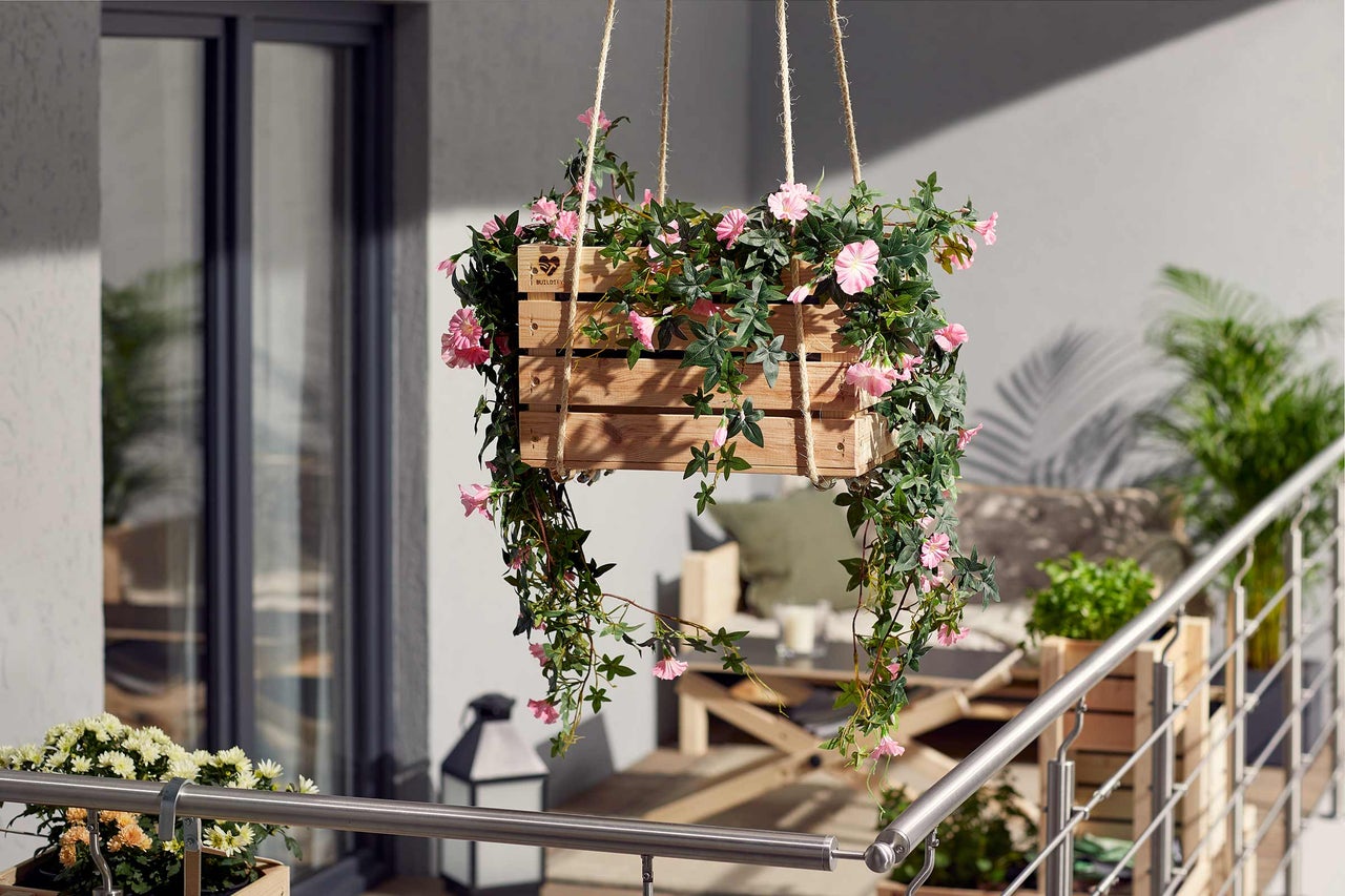 Hängande trälåda med rosa blommor och gröna blad för utomhusbruk.