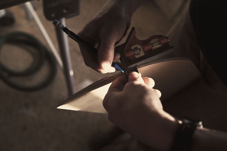 En person markerar en träskiva med en penna och en vinkelhake.