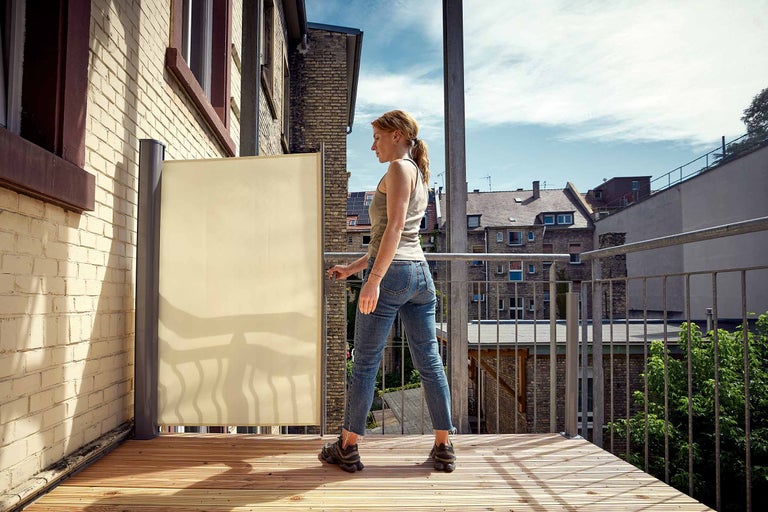 Kvinna använder insynsskydd på balkongen