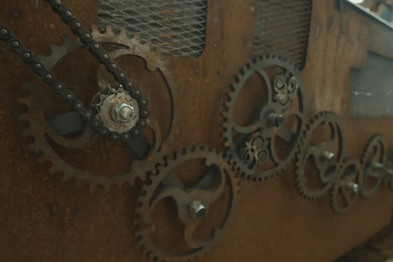 Närbild av metallkugghjul med kedja på en träyta