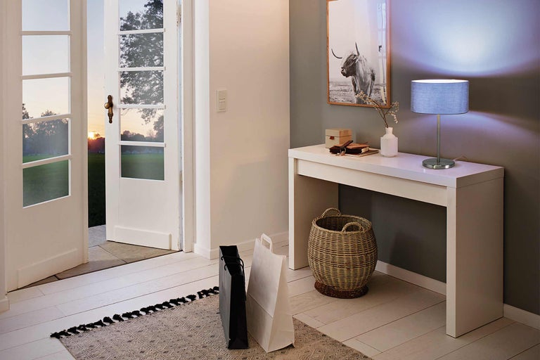 Entré med vitt konsolbord, lampa och dekoration