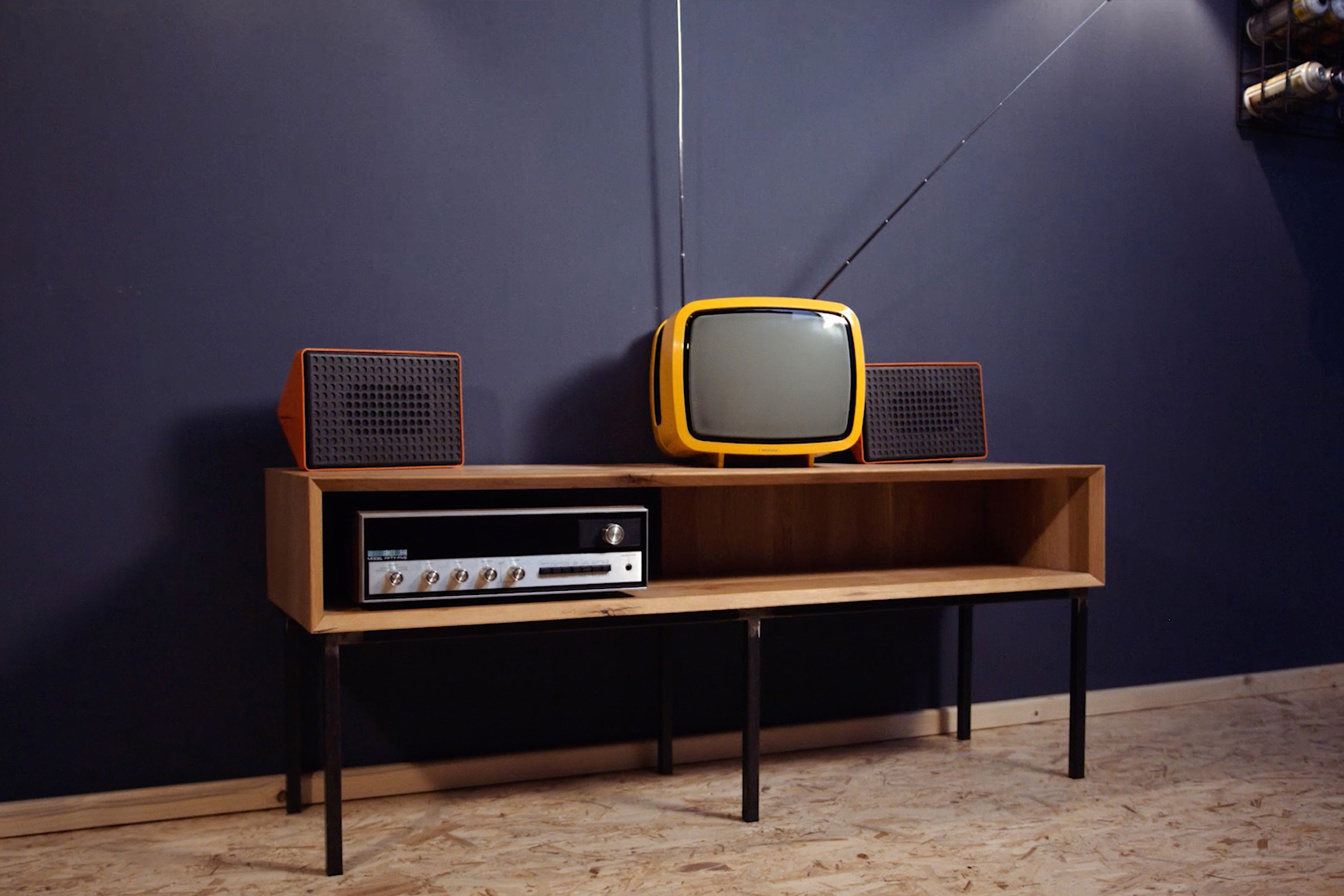 Retroinredning med TV, högtalare och mottagare på en låg skänk