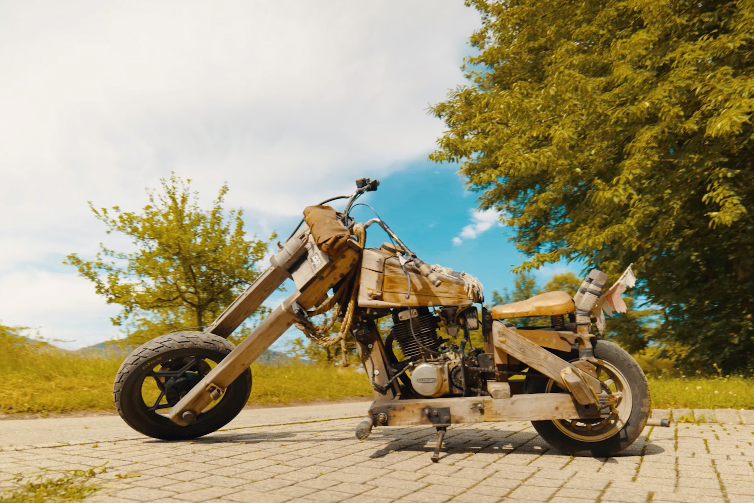 Motorcykel av trä med motor på gatsten