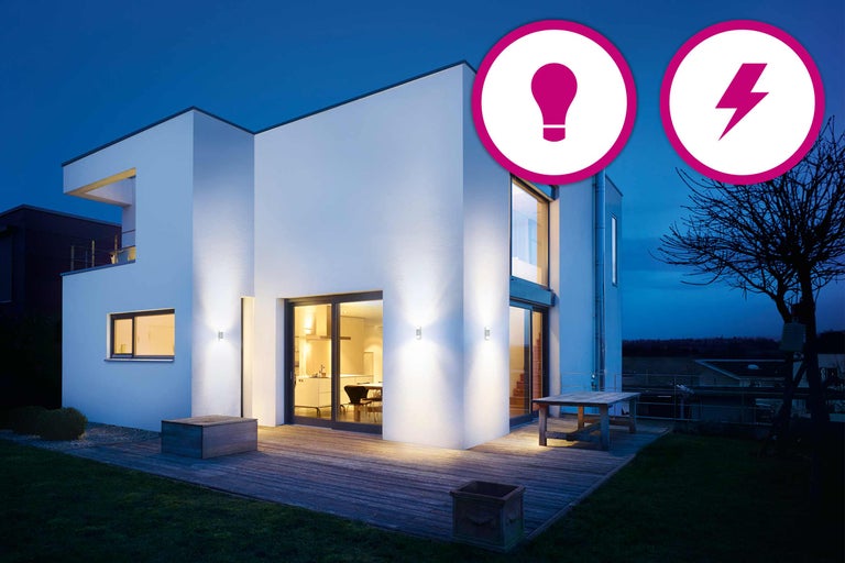 Modernt hus med utomhusbelysning och energisparsymbol