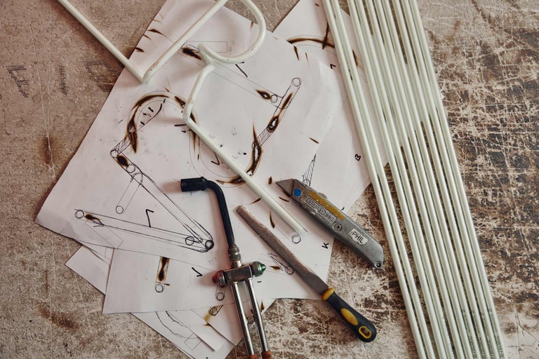 Skissblad, verktyg och rör på en arbetsyta