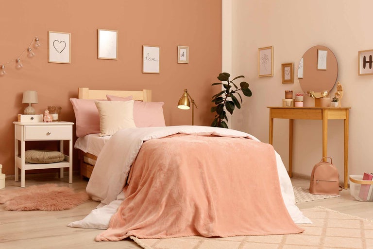 Ljust sovrum med säng, sängbord och byrå i modern design.