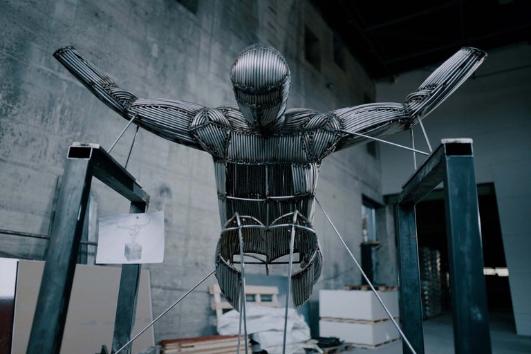 Skulptur av en man gjord av metallstänger i ett lager