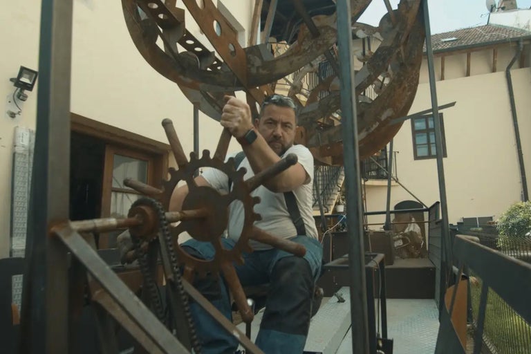 Man som använder en stor metallkonstruktion utomhus.