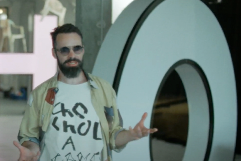 Man som står framför en stor bokstav O.