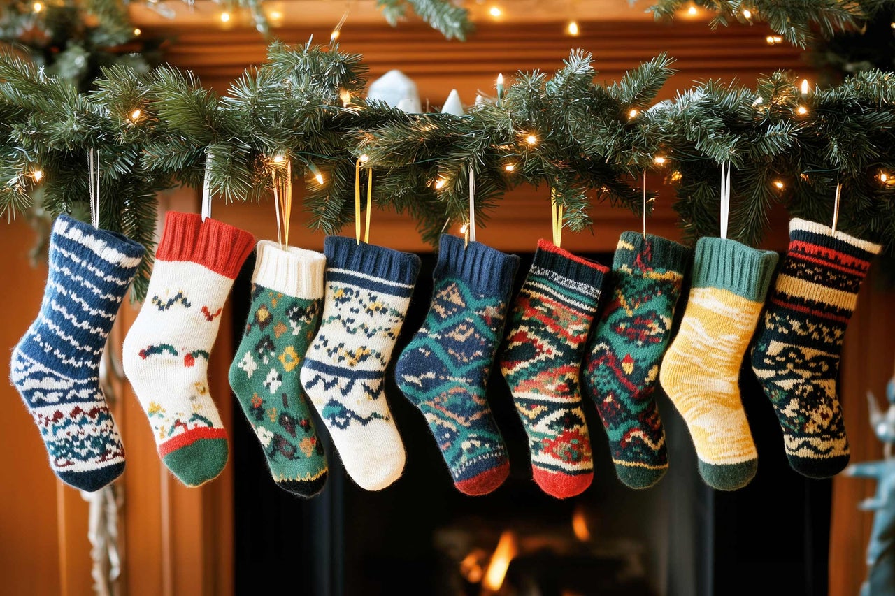 Dekorativ spis med julgirlang och broderade strumpor för en festlig atmosfär