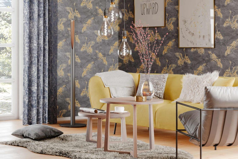 Ljust vardagsrum med gul soffa, träbord, golvlampa och mönstrad tapet