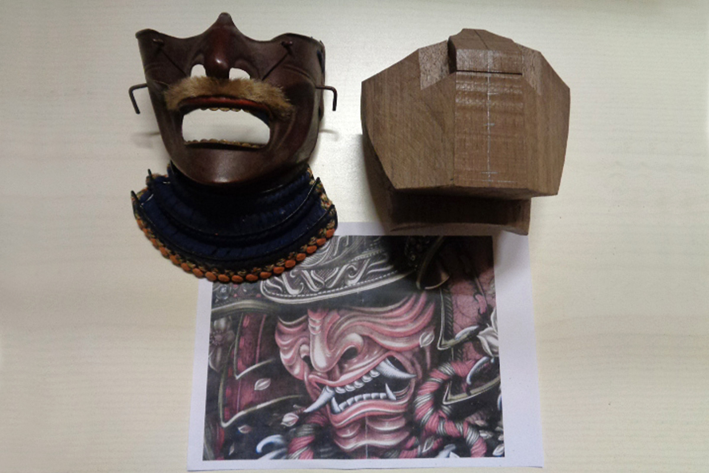 Samurajmask med bröstplåt, träblock och samurajteckning