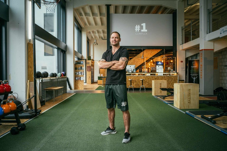 Man står i ett modernt gym med sportutrustning