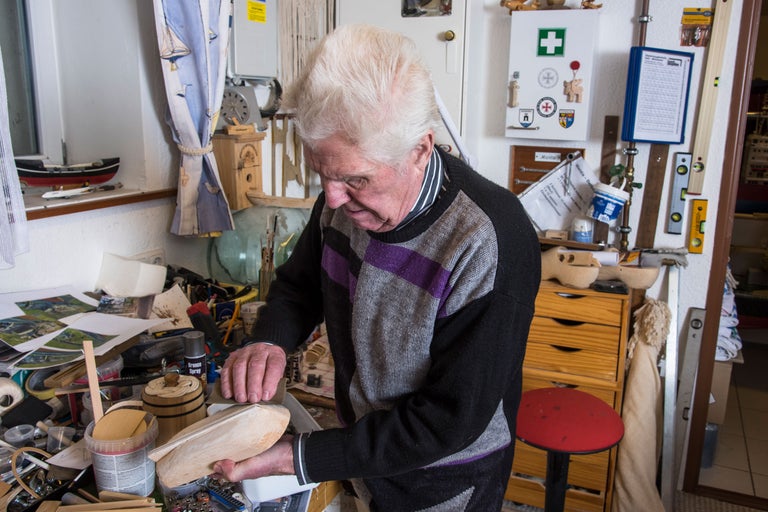 Man slipar träbit i verkstad med verktyg och tillbehör