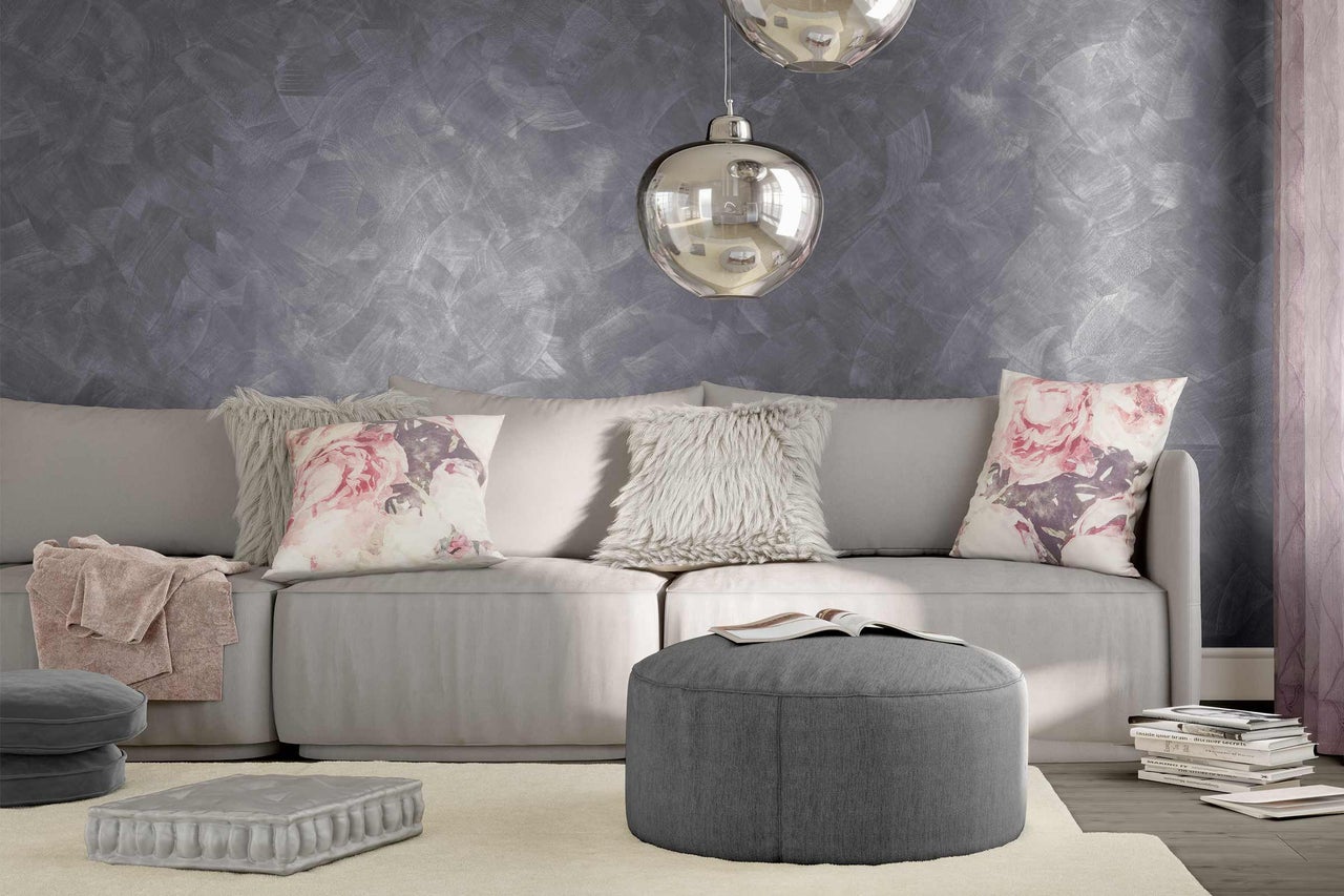 Ljust vardagsrum med soffa, kuddar, pall och dekoration