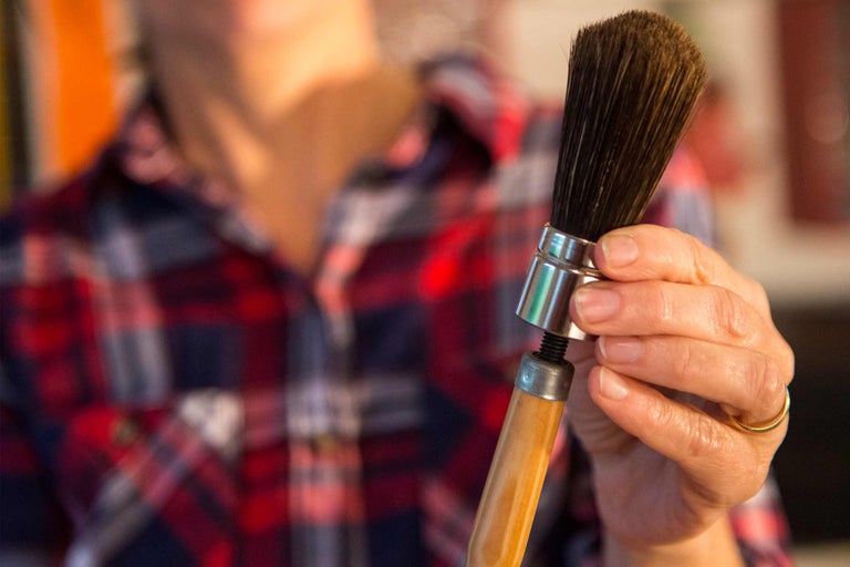 Rund borste med trähandtag i handen