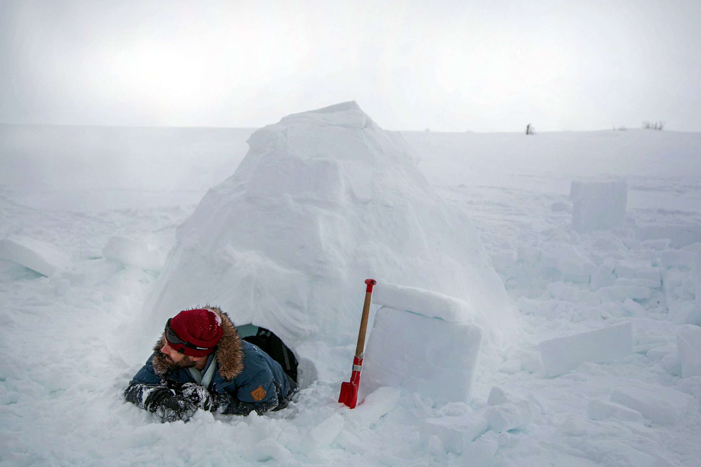 Man bygger igloo med spade i snön
