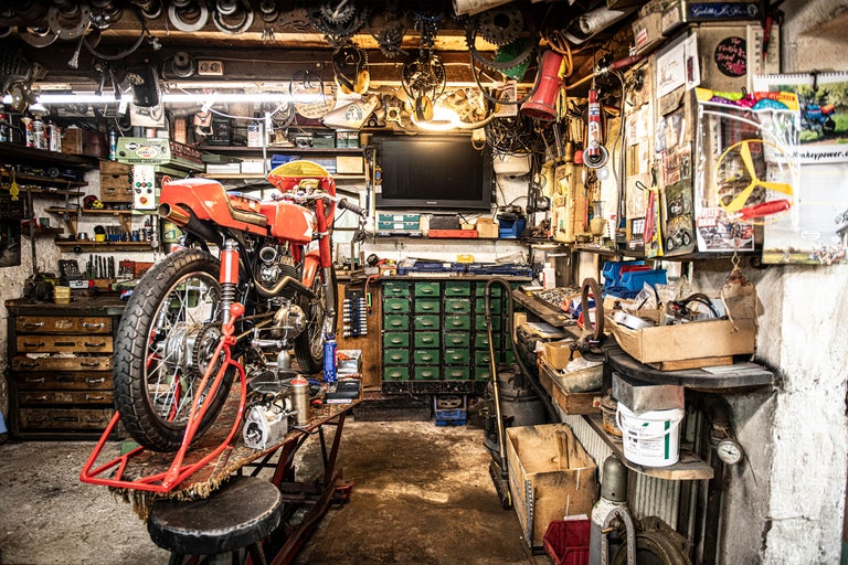 Verkstad med motorcykel på lyftplattform, verktyg och arbetsbänk