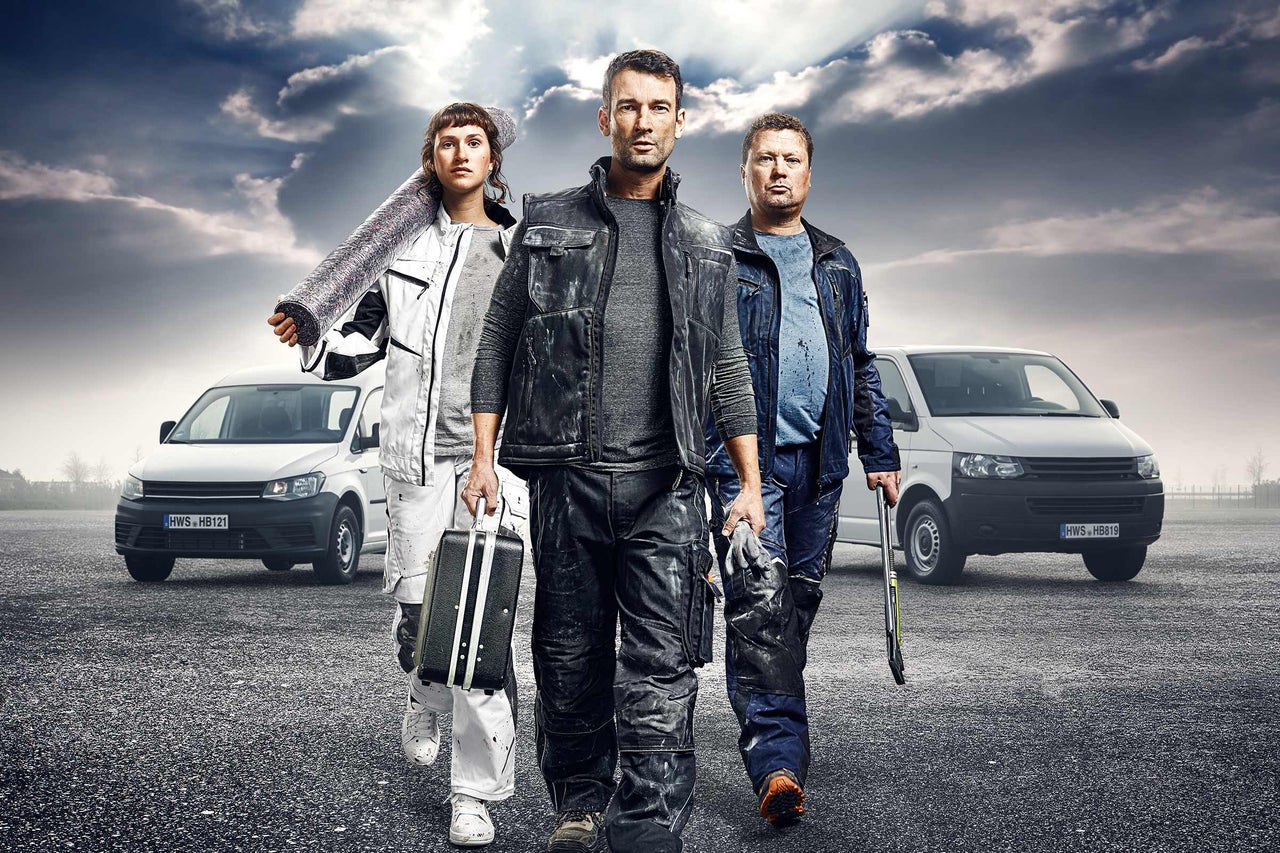 Tre hantverkare med verktyg och skåpbilar