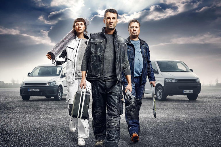 Tre hantverkare med verktyg och skåpbilar