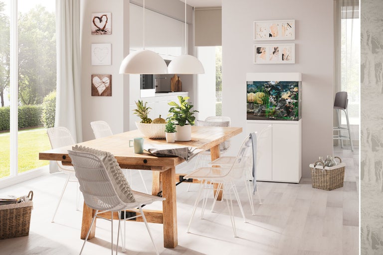 Ljust vardagsrum med matbord, stolar, akvarium och dekorationer