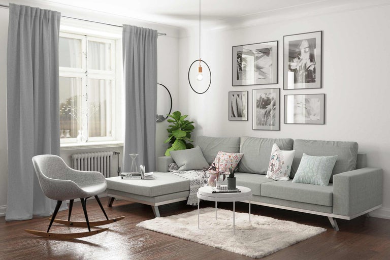 Vardagsrum med grå soffa, grå gardin, pendellampa och dekoration