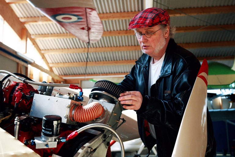 Man reparerar flygplansmotor i en verkstad.