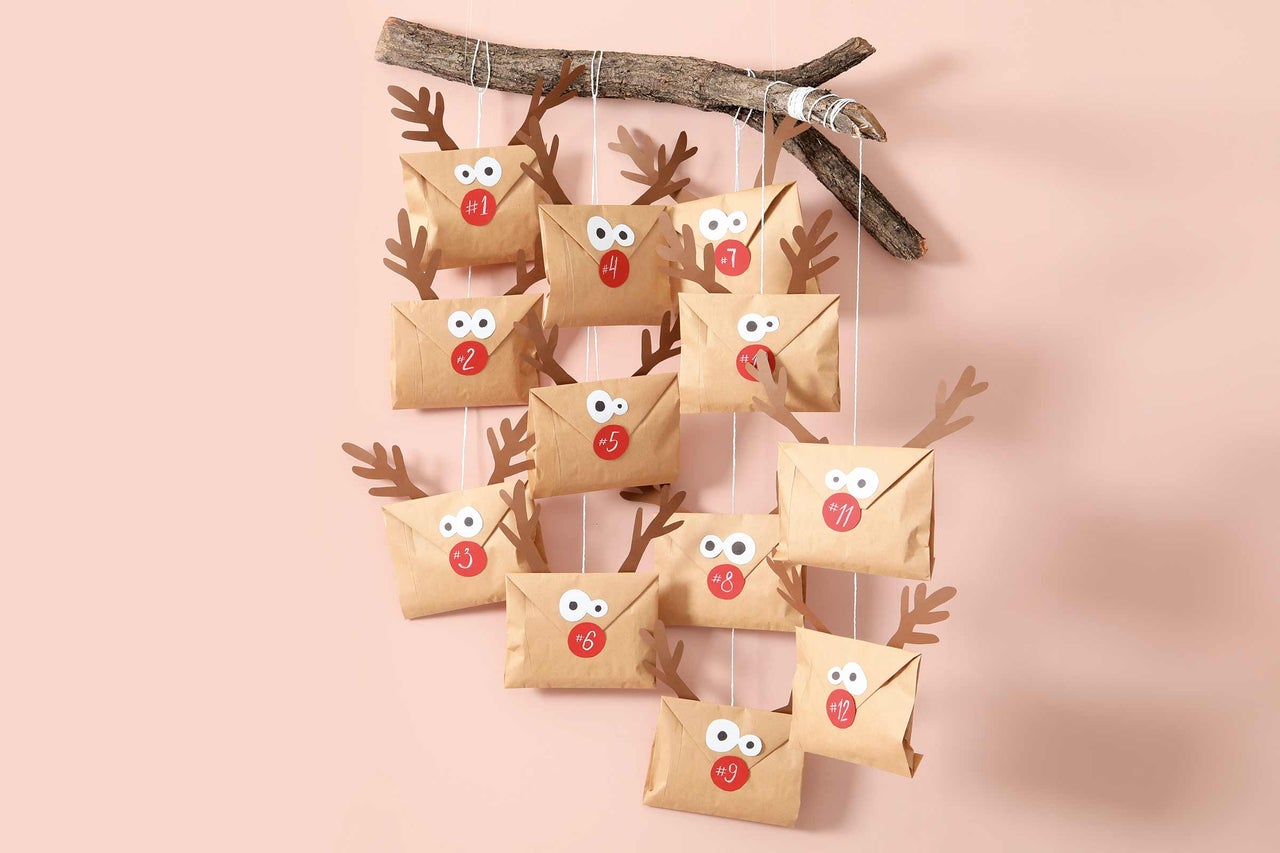 DIY adventskalender med papperskuvert, pappershorn och en gren som upphängning