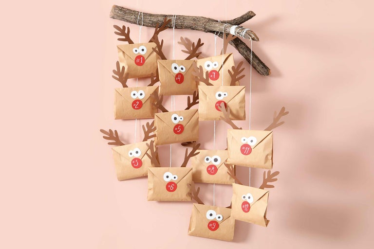 DIY adventskalender med papperskuvert, pappershorn och en gren som upphängning