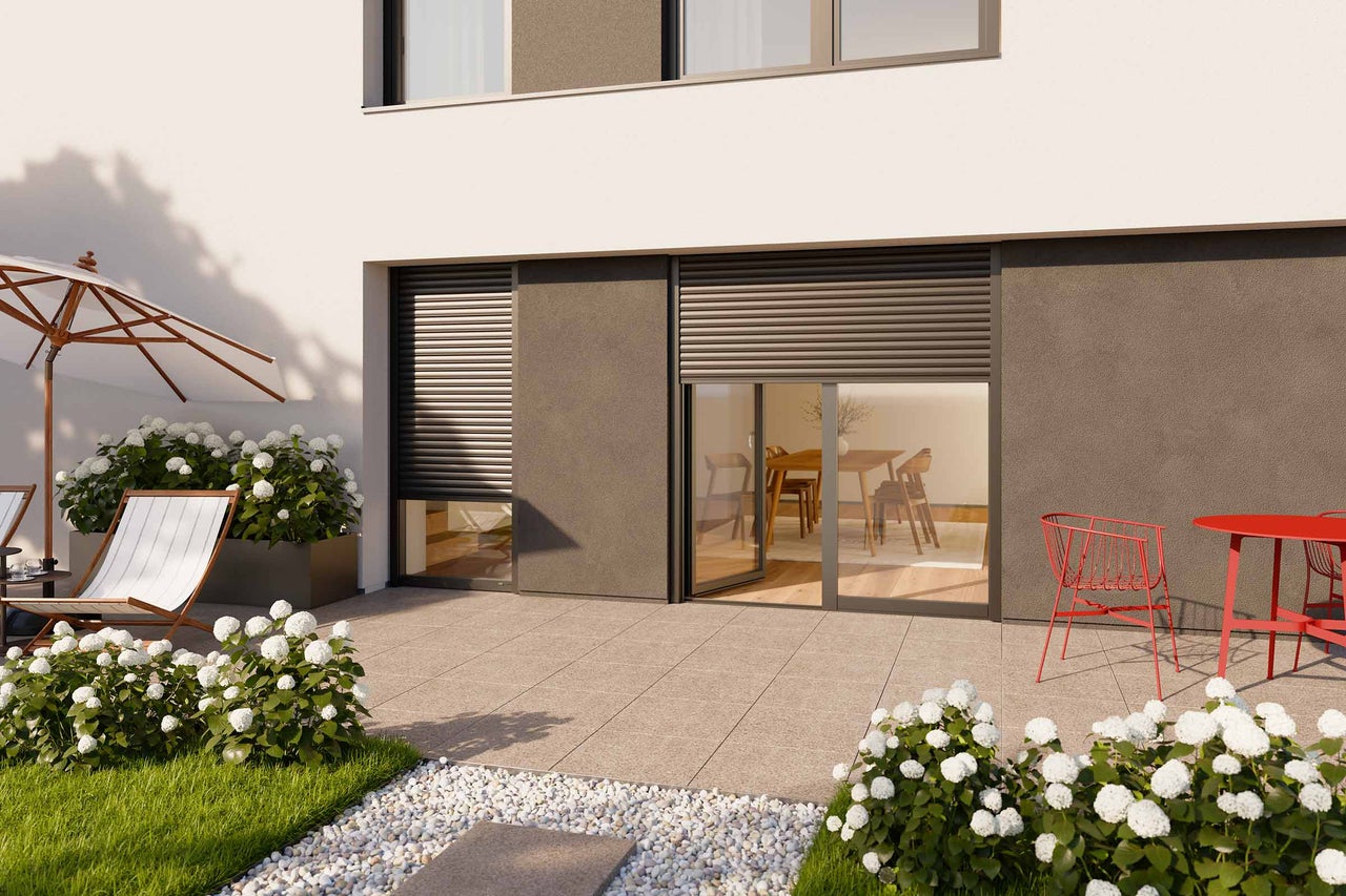 Terrass med rullgardiner, trädgårdsmöbler och blomsterrabatter